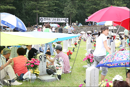 현충일을 맞아 국립현충원 묘소에서 헌화하는 유족들 